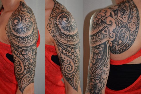 Tribal-Tattoo mit Augen auf Oberarm und Schulter